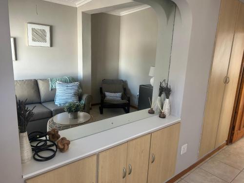 a kitchen with a living room with a couch at The College Suite, Mill Park in Gqeberha