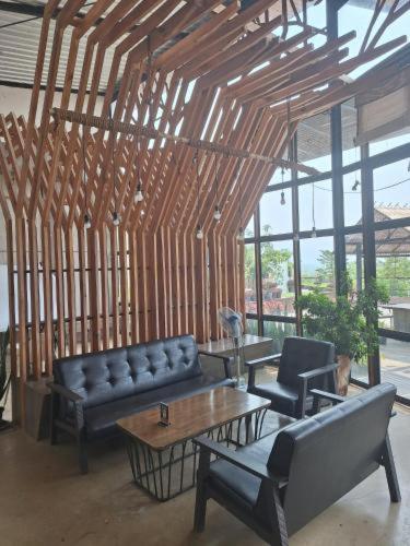 ein Wohnzimmer mit Sofa und Tisch in der Unterkunft Rai Ruen Rom Organic and Farmstay in Ban Sawan