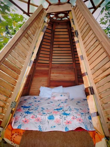 a bed in a wooden bed frame in a tent at Tipi Miramelinda in Baños