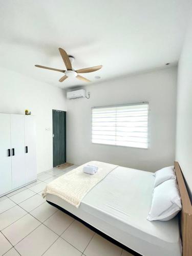 a white bedroom with a bed and a ceiling fan at My Homestay in Tuaran