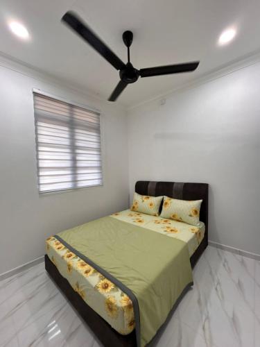 a bedroom with a bed with a ceiling fan at Dneesya homestay in Kuala Terengganu
