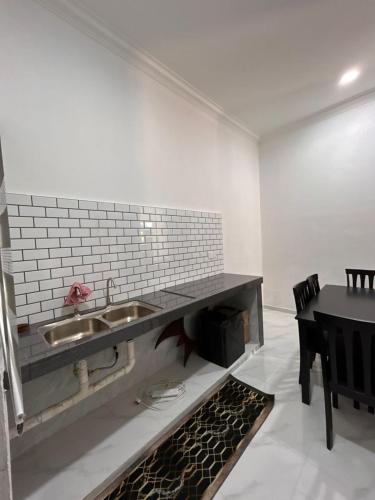 a kitchen with a sink and a table with chairs at Dneesya homestay in Kuala Terengganu