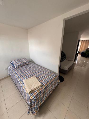 una camera da letto con un letto con una coperta scozzese di Punto base aérea a Cali
