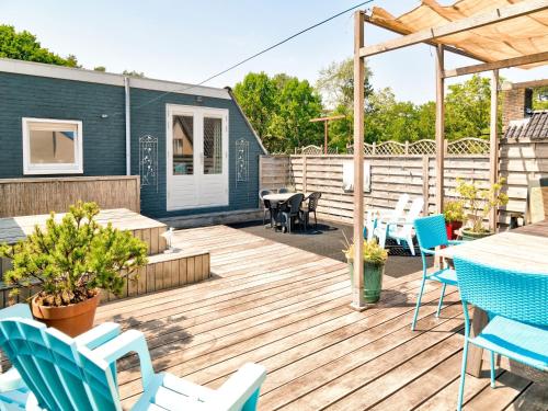 een terras met blauwe stoelen en een tafel en stoelen bij Stunning apartment in Schoorl, North Hollandâ you can bike to the beach in Schoorl