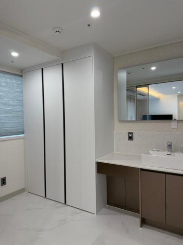 a bathroom with a sink and a mirror at Raviens Maison de Hotel in Busan