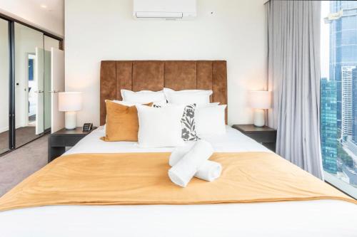 a bedroom with a white bed with a large window at Luxury Apartment with Stunning Southbank Views in Melbourne