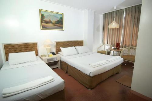 a hotel room with two beds in a room at Hotel Supreme in Baguio