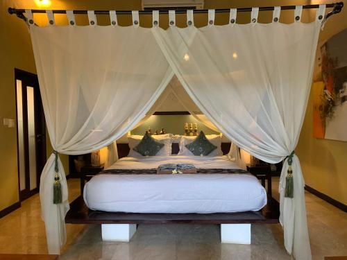 een slaapkamer met een hemelbed bij Nike Villas in Sanur