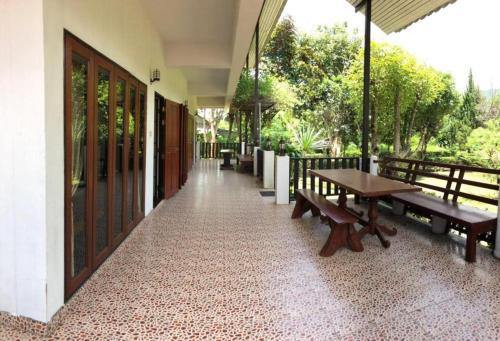 a porch with benches and a table on a building at LUCKY PAI Resort&Hostel in Pai