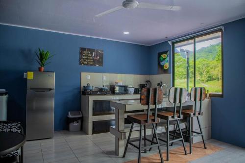 eine Küche mit blauen Wänden sowie einem Tisch und Stühlen in der Unterkunft Apartment Steps fr View Los Sueños Adventure Park in Herradura
