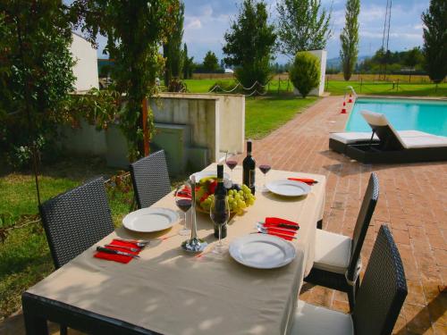 een tafel met borden en een fles wijn bij Modern holiday home in Foligno - Loc with pool in Case Vecchie