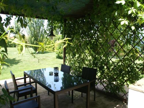 een tafel en stoelen in een tuin met een heg bij Modern holiday home in Foligno - Loc with pool in Case Vecchie