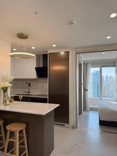 una cucina con isola e un letto in una stanza di Raviens Maison de Hotel a Busan