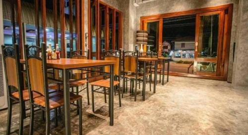 een groep tafels en stoelen in een restaurant bij Theloft boutique nakhonpanom in Ban Noi Pho Kham