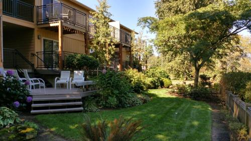 a house with a yard with chairs and trees at Lewis River Inn in Woodland
