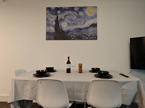 a table with a bottle of wine and two chairs at Sky High Harbour Bridge View - Sydney Olympic Park in Sydney