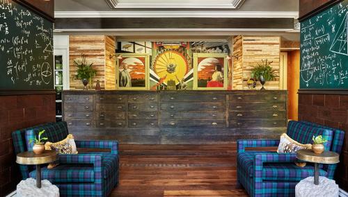 a restaurant with two blue chairs and a chalkboard at Graduate by Hilton Ann Arbor in Ann Arbor