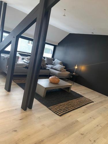ein Wohnzimmer mit Sofa und Tisch in der Unterkunft NEOZONE Appart-Hotel Malmedy in Malmedy