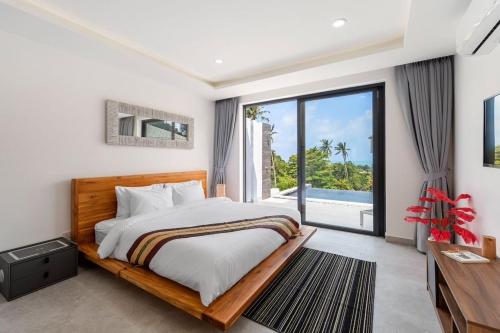 ein Schlafzimmer mit Bett und Meerblick in der Unterkunft Elsa Villa in Strand Chaweng Noi