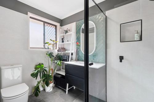 a bathroom with a sink and a toilet and a mirror at Exclusive Living for Professionals in Seacliff