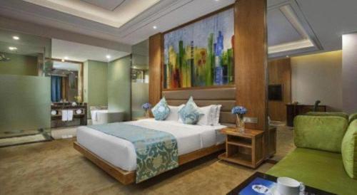 een slaapkamer met een groot bed en een bank bij Ramada by Wyndham Taixing in Taixing