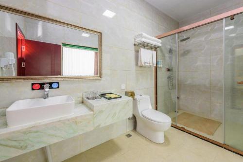 een badkamer met een wastafel, een toilet en een douche bij Guilin Wanjing Hotel in Guilin