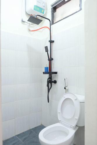 a bathroom with a white toilet and a mirror at Elmo Living in Yogyakarta