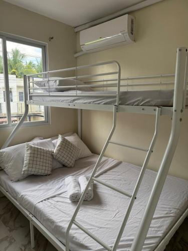 a bedroom with two bunk beds and a window at BLJ Homes in Angatan