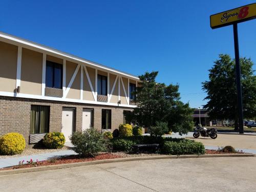 a building with a motorcycle parked in front of it at Super 8 by Wyndham Bentonville in Bentonville