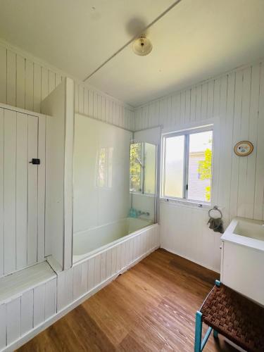 a bathroom with a tub and a sink and a window at Noosa River Gem in Noosaville