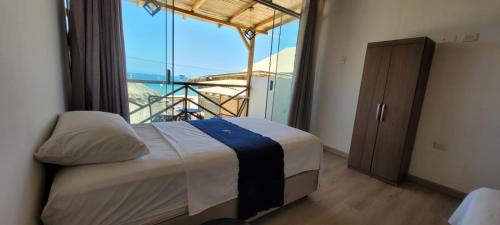 a bedroom with a bed with a view of the ocean at Black Marlin - Restaurant and Lodge in Talara