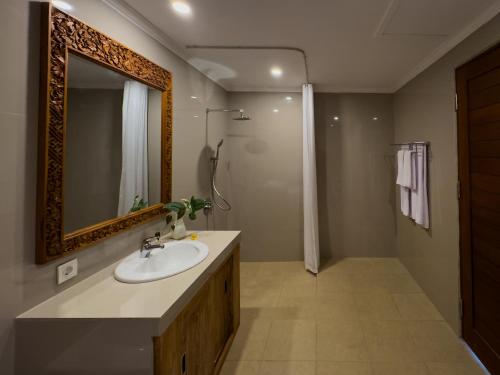 a bathroom with a sink and a mirror at Koeluma Bali in Ubud