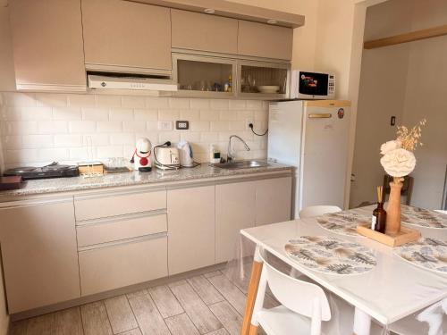 a kitchen with white cabinets and a table with chairs at Martita House in Clorinda