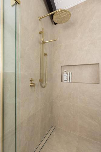 a bathroom with a shower with a glass door at Pet friendly downtown Mt Maunganui 3 bedroom home in Mount Maunganui