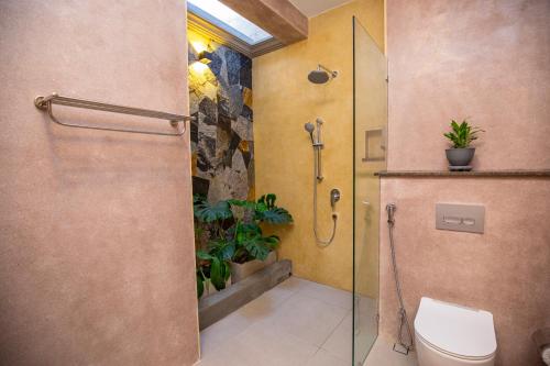 a bathroom with a toilet and a glass shower stall at La Lassaura in Unawatuna