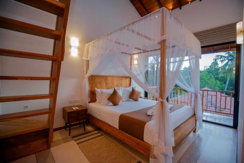 a bedroom with a canopy bed and a balcony at La Lassaura in Unawatuna