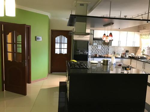 eine Küche mit grünen Wänden und einer schwarzen Arbeitsplatte in der Unterkunft Casa Regina in Lusaka