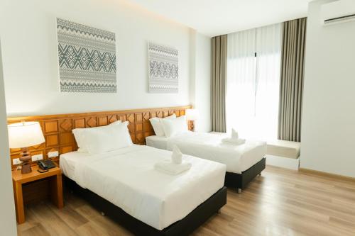 a hotel room with two beds and a window at Sann Boutique Nan in Nan