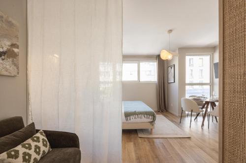 a living room with a bed and a dining room at Studio moderne et climatisé - proche Paris in Le Pré-Saint-Gervais