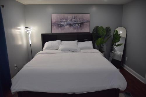a large white bed in a bedroom with a painting at Airende in Newark