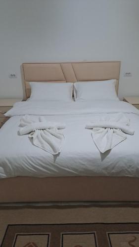 a bed with white towels on top of it at Aleko Guesthouse in Përmet