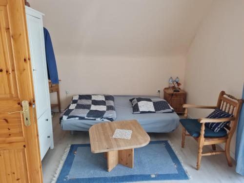 a bedroom with two beds and a table and a chair at Ferienwohnung Quickborn in Quickborn