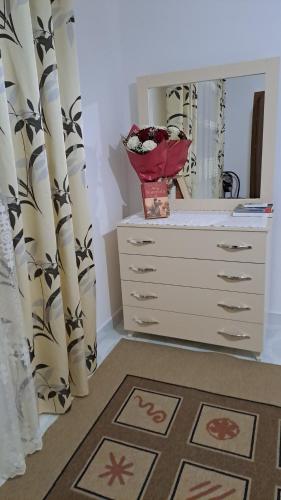 a dresser with a mirror and a dresser with curtains at Aleko Guesthouse in Përmet