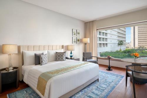 孟买孟买欧贝罗伊酒店的一间卧室，配有一张大床和一扇大窗户。