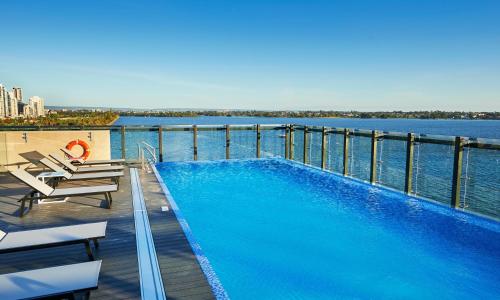 ein Swimmingpool auf einem Gebäude neben dem Wasser in der Unterkunft Doubletree By Hilton Perth Waterfront in Perth