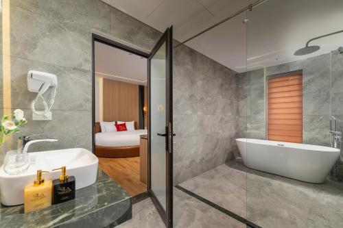 a bathroom with a white tub and a sink at Lam Anh Hotel 9 Him Lam Vạn Phúc in Hà Ðông