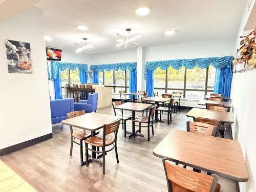 un ristorante con tavoli, sedie e tende blu di Baymont by Wyndham Tallahassee a Tallahassee