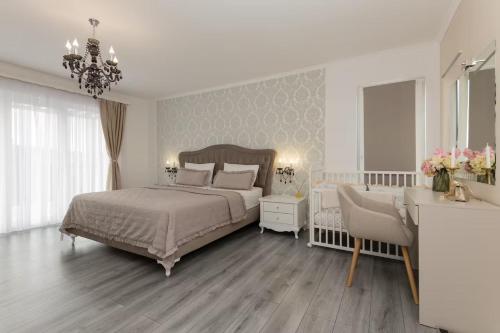 une chambre avec un lit, une table et un lustre dans l'établissement Villa Viktoria with private pool, barbecue, gym, children's playground, à Krivodol