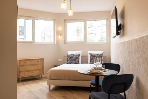 a bedroom with a bed and a table with chairs at Charming and air-conditioned - Close to Paris in Le Pré-Saint-Gervais