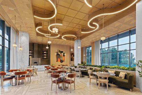 un ristorante con tavoli e sedie e grandi finestre di Fortune Select Siliguri a Binnāguri